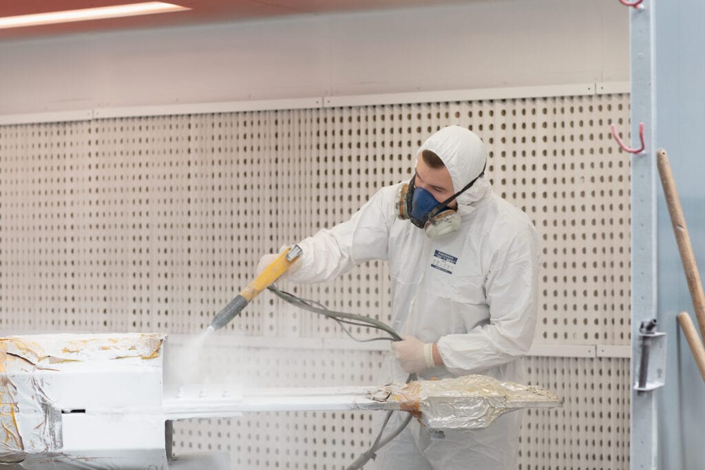 Marcote expert spraying parts with coating